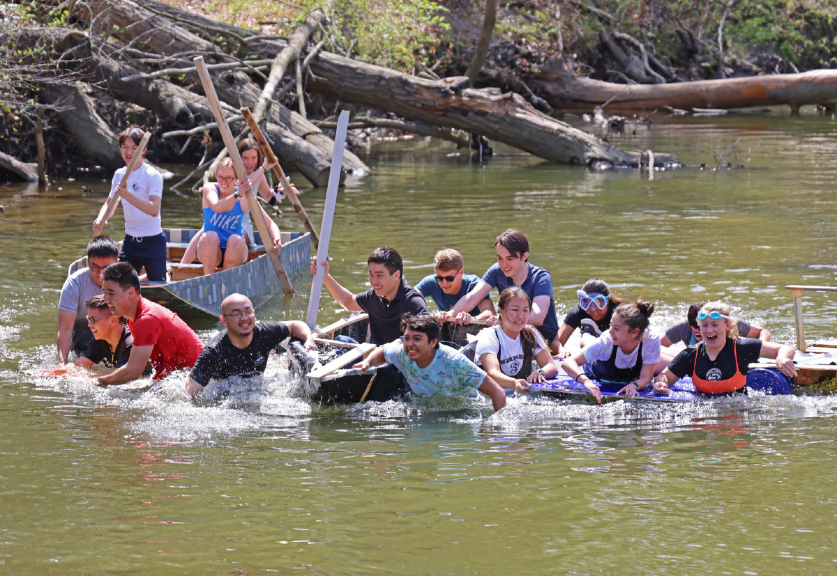 students rowing in river