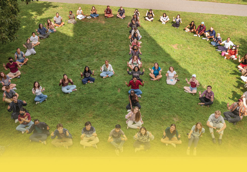 group of incoming college students sitting together in the shape of a peace sign