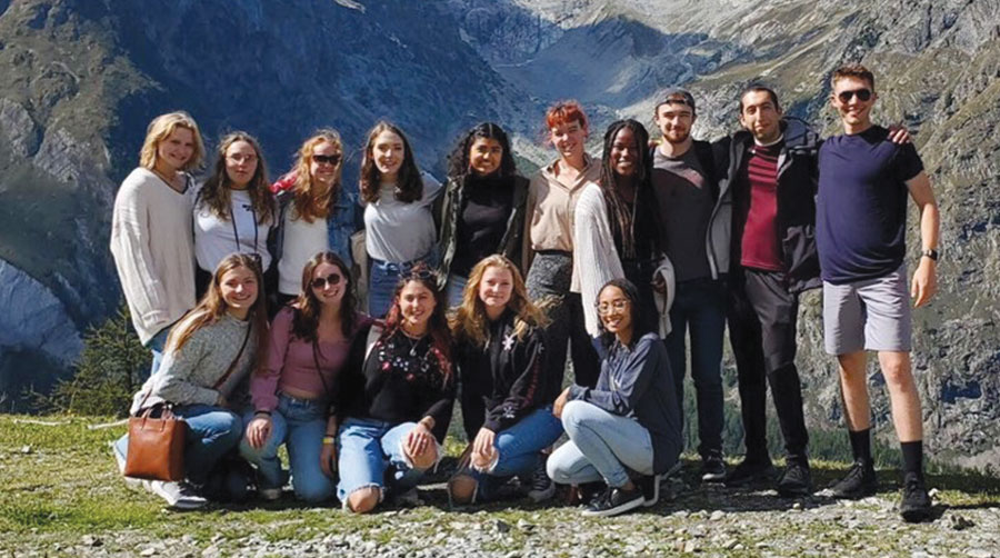 Students studying abroad posing for a picture in front of scenery