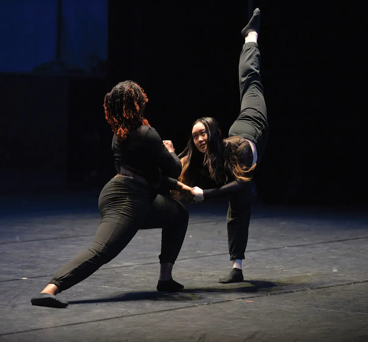 Two students in black uniforms dancing