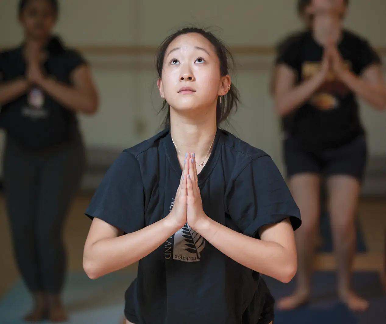 Student with hands in a praying position looking up