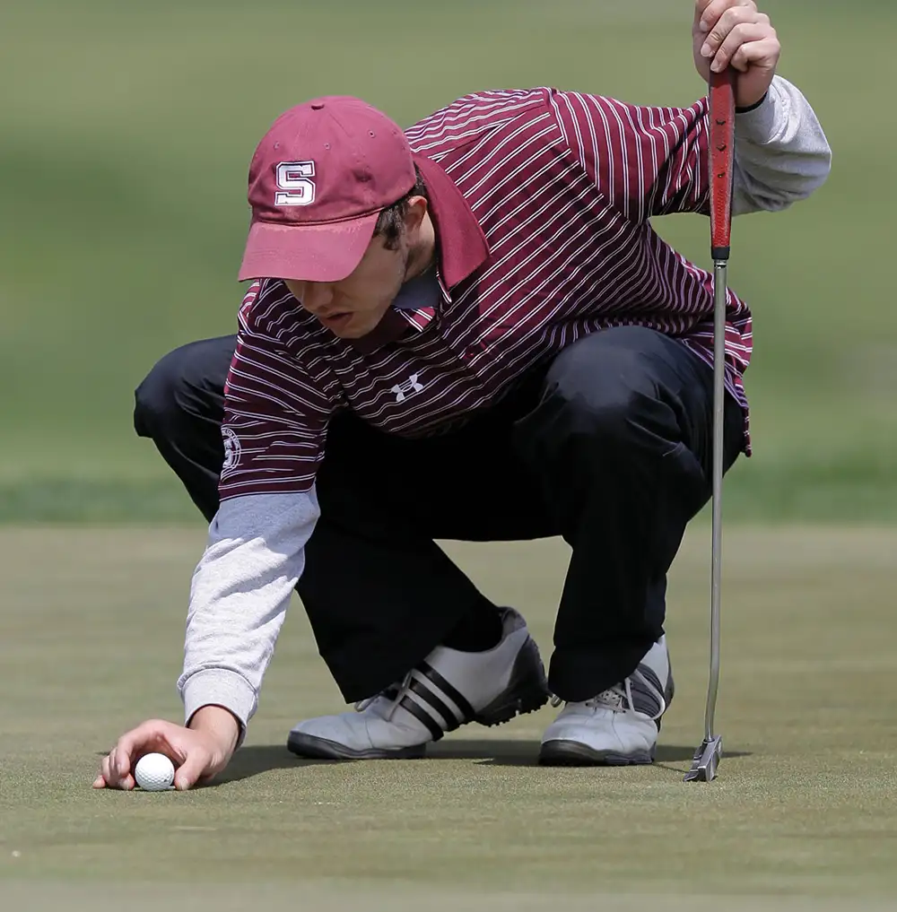 Swarthmore golfer kneeling placing ball