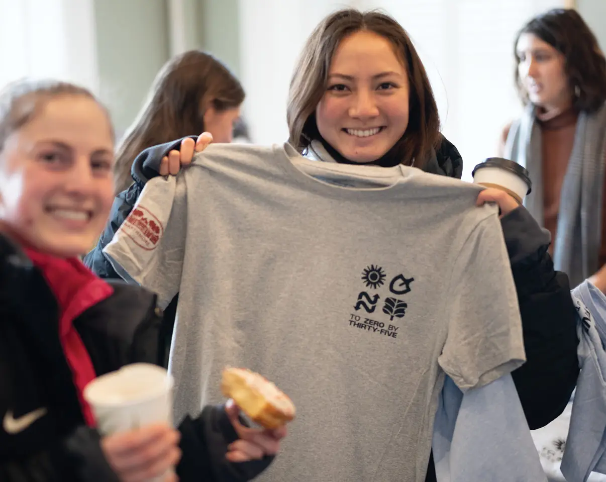 Students smiling and holding up shirt representing Swarthmore sustainability efforts