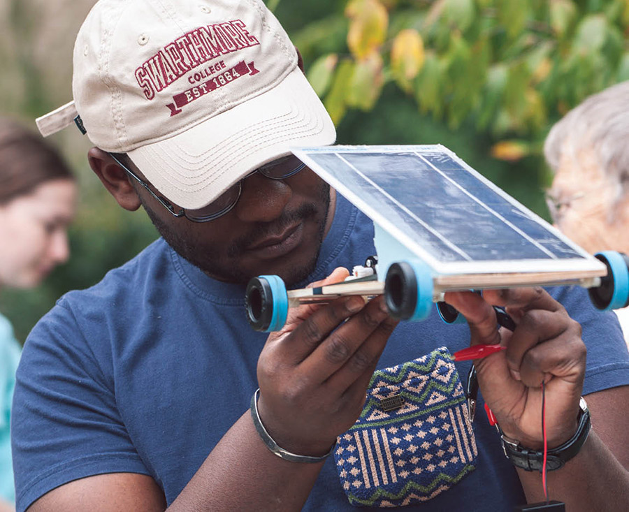 Swarthmore student looking at solar powered remote control car