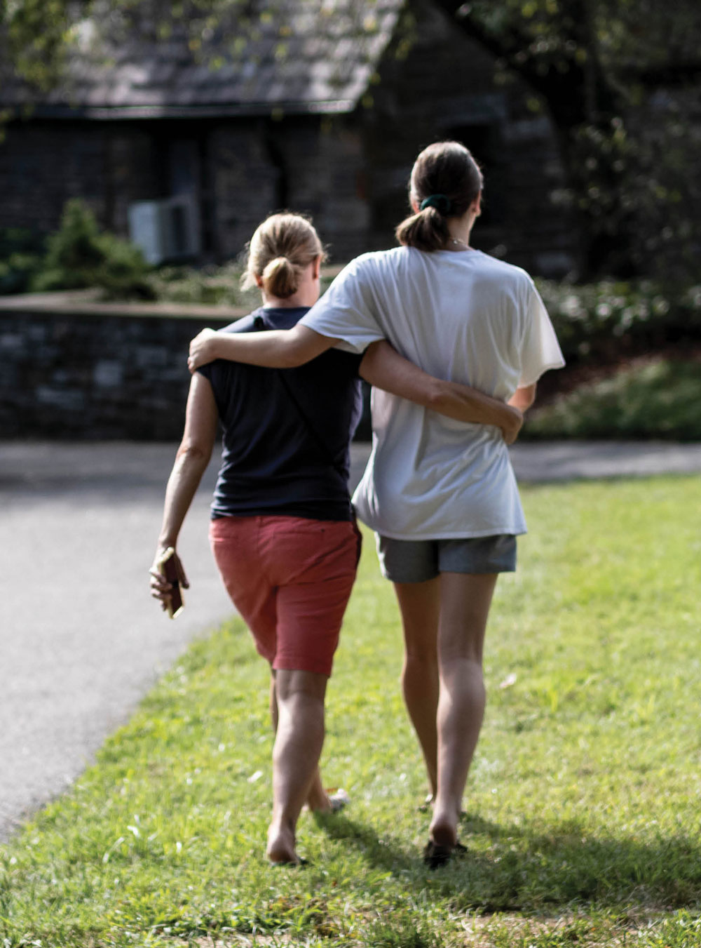 two people walking with their arms around each other