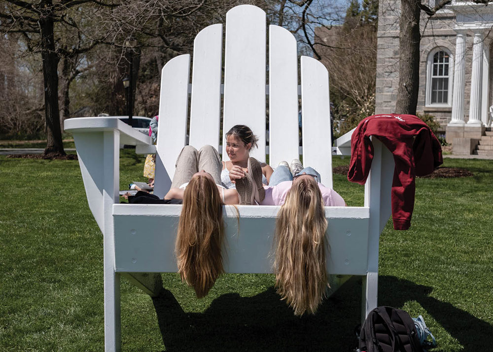 three kids sitting on a large white chair