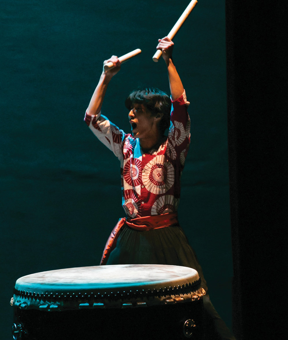 student at a dance concert dress rehearsal about to play a large drum