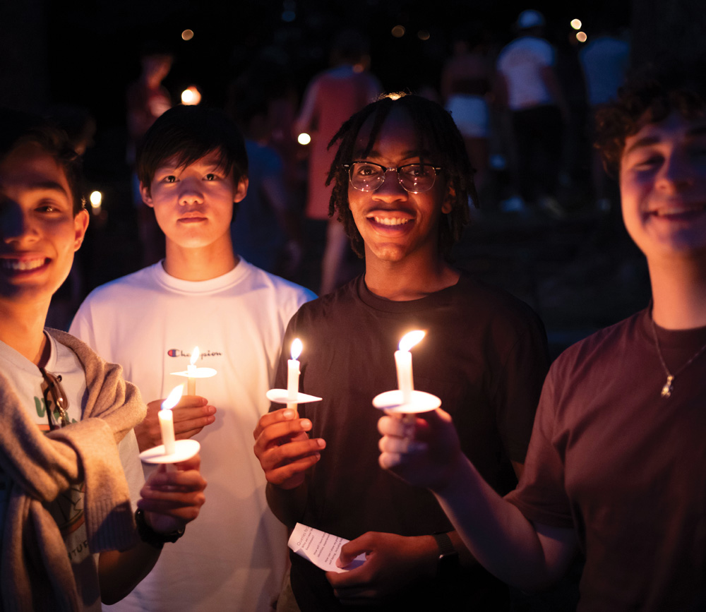 students holding candles at night