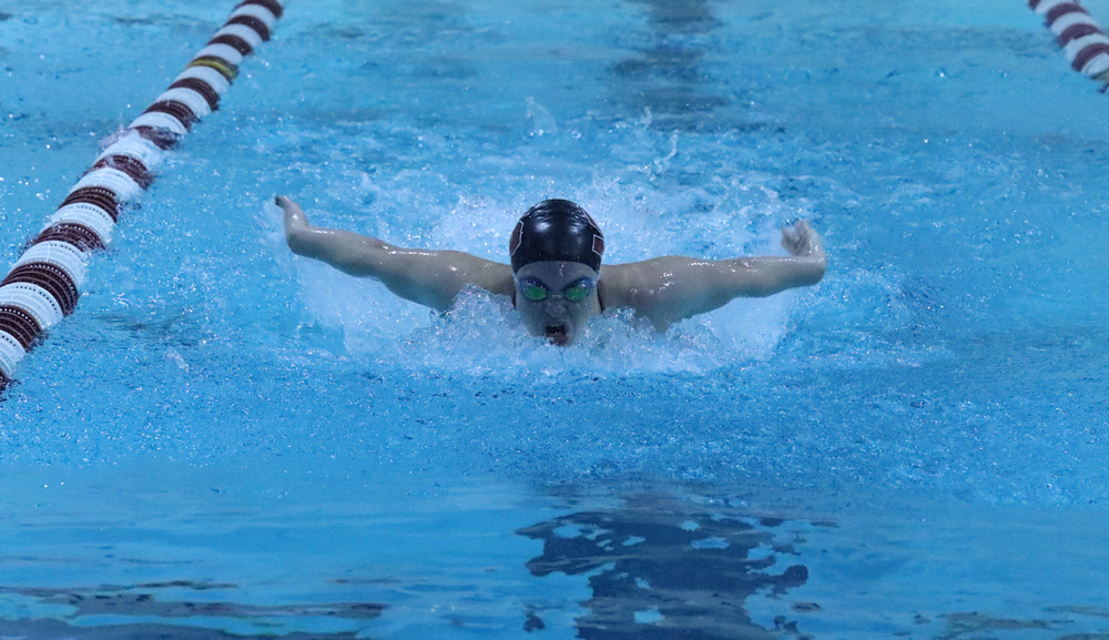 head on view of a swimmer wearing a cap and goggles